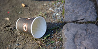 Ein weggeworfener Kaffeebecher liegt auf der Straße