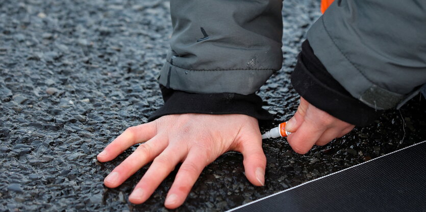 Hand auf Asphalt