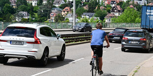 Autos neben einem Mensch auf einen Fahrrad