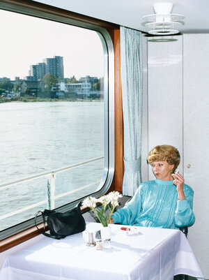 Eine Frau sitzt in einem Schiffsrestaurant und schaut rauchend aus dem Fenster, 1994