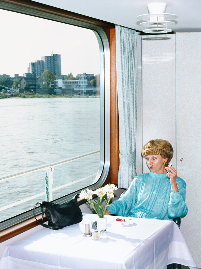 Eine Frau sitzt in einem Schiffsrestaurant und schaut rauchend aus dem Fenster, 1994