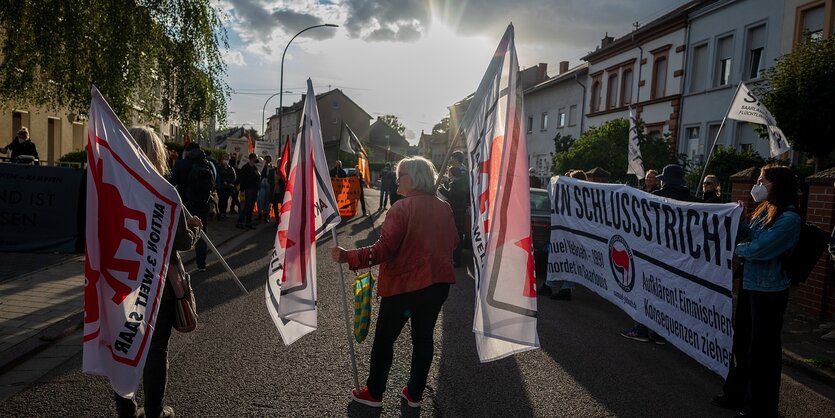 Menschen mit Fahnen demonstrieren in einer ruhigen Wohngegend