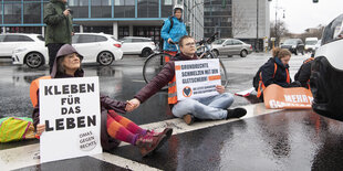 Mitglieder der Gruppe Letzte Generation blockieren stadtaus- und stadteinwärts den Ernst-Reuter-Platz mit einer Sitzblockade auf der Straße.