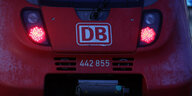 Ein Zug der Deutschen Bahn DB mit roten Lichtern steht am frühen Morgen im Hauptbahnhof Rostock