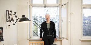 Paul Brodowsky steht am geöffneten Fenster einer Altbauwohnung