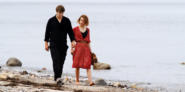 Leon (Thomas Schubert) mit Nadia (Paula Beer) gehen am Strand entlang.