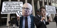Menschen demonstrierne mit den Masken von Tucker carlson und Rupert Murdoch