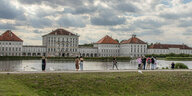 Blick auf das Schloss Nymphenburg, im Vordergrund sind Touristen zu sehen