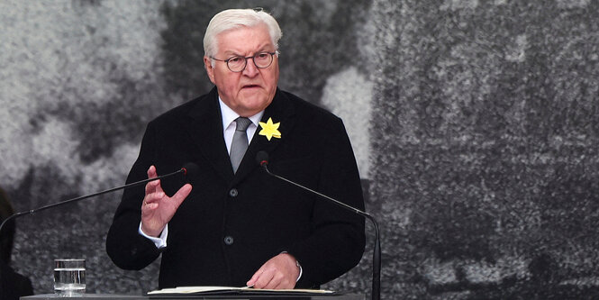 Steinmeier redet vor der Kulisse eines historischen Fotos aus dem Warschauer Ghetto