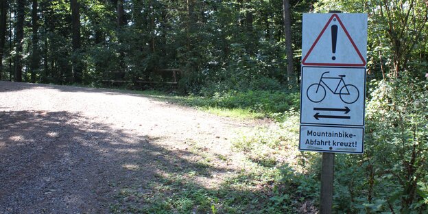 Ein Schild warnt vor kreuzenden Radfahrern im Wald Ein Schild warnt vor kreuzenden Radfahrern im Wald