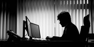 Silhouette eines Mannes, der am Computer arbeitet