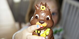 Ein Schokoladenosterhase ohne Ohren in KInderhänden