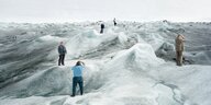 Fotografierende Menschen stehen in Grönland auf Eis