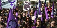 Frauen demonstrieren mit lilafarbenen Fahnen