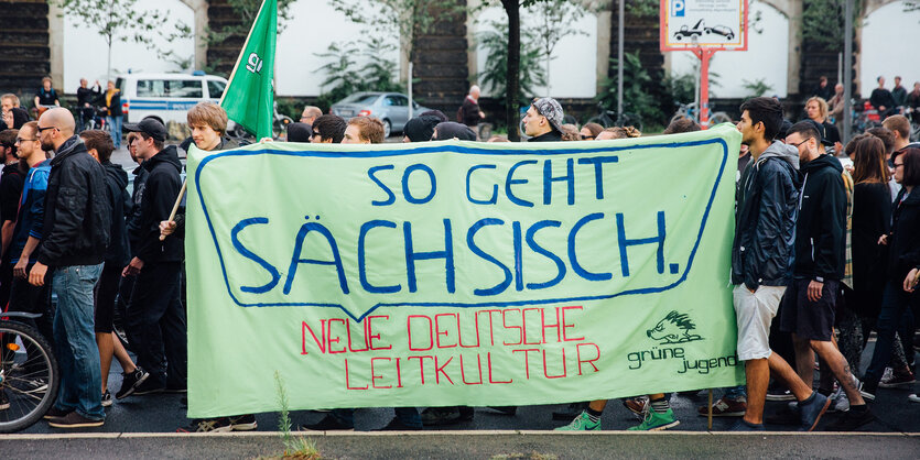 Antifa-Demonstrant_innen tragen ein Transparent mit der Aufschrift: „So geht Sächsisch“