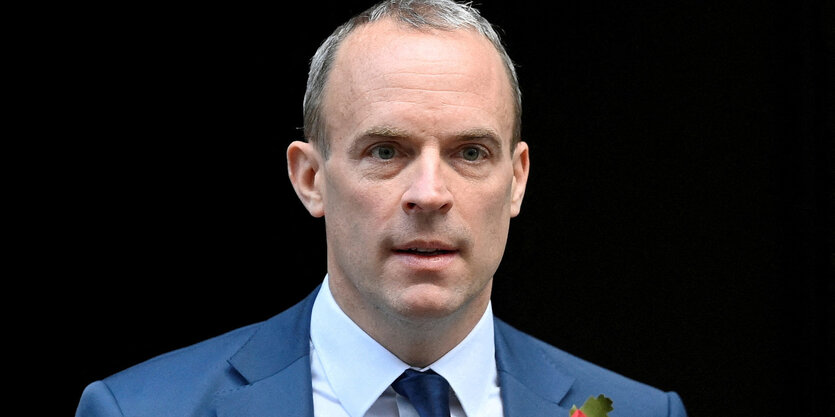 Raab hat Geheimratsecken, graue kurze Haare, schaut ernst und trägt einen Anzug