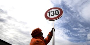 Ein mann hält ein Schild mit der Aufschrift "130"