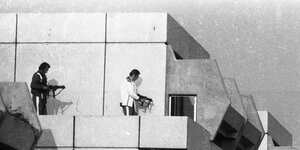 Zwei Männer mit Waffen auf dem Dach eines Hochhauses