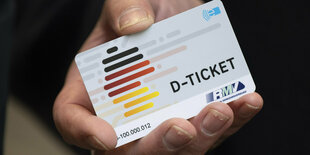 Hand hält Deutschlandticket