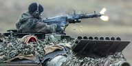 Ein Soldat auf einem Panzer feuer aus einem Maschinengewehr