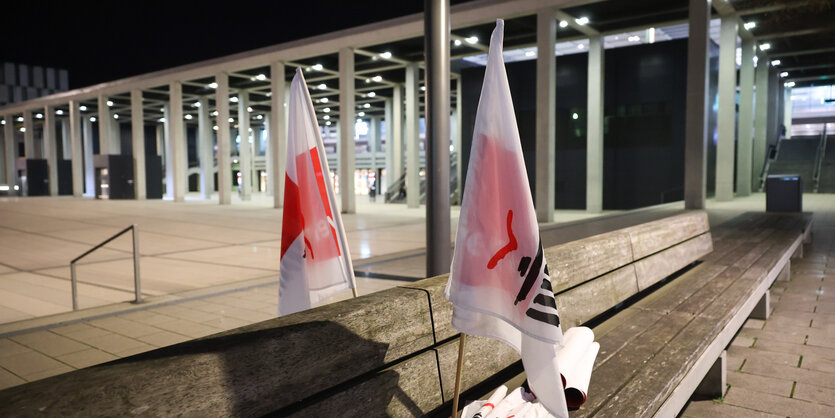 Fahnen der Gewerkschaft Verdi stecken vor dem Terminal des Flughafens BER