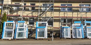 Ein mietshaus wird saniert, neue Fenster sollen eingebaut werden und stehen schon vor dem Haus auf der Straße