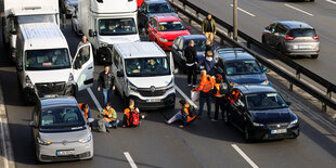 Menschen sitzen auf der Straße und verursachen einen Stau auf der Autobahn