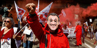 Ein Mensch protestiert mit einer Maske des französischen Präsidenten Emmanuel Macron