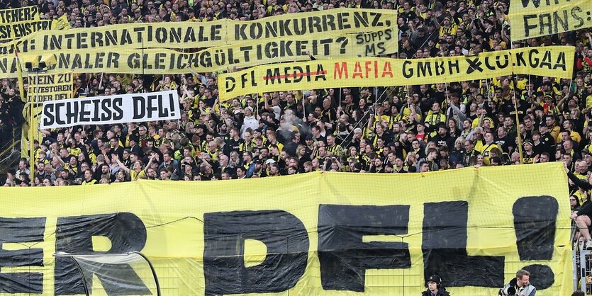 Transparente vor der Tribüne gegen Investoren in der DFL