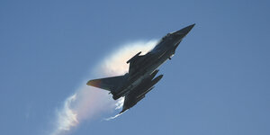 Ein Kampfjet steigt vor blauem Himmel auf