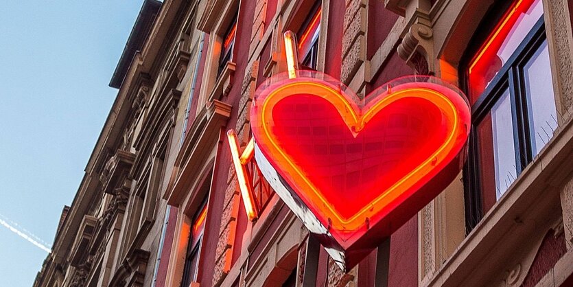 Ein rotes Neonherz an einer Hausfassade