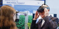 Bundeskanzler Olaf Scholz nimmt am Girls' Day-Auftakt im Kanzleramt teil und schaut an einem Stand durch eine VR-Brille.