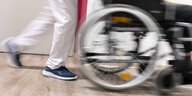 Eine Pflegekraft schiebt einen Rollstuhl, Detailaufnahme