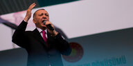 Erdoğan spricht in ein Mikrofon und gestikuliert