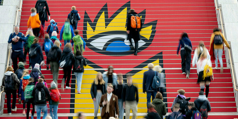 Menschen auf einer Treppe, auf die das Logo der leipziger Buchmesse aufgemalt ist