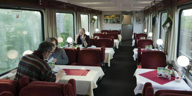 Tschechischer Speisewagen mit drei Passagieren. auf den Tischen weiße Decken und rote Läufer
