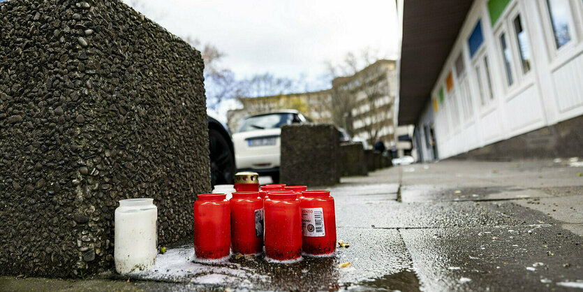 Grabkerzen stehen vor einem Gebäude