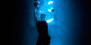 Tzusing unter Wasser mit Hanteln in Luftblasen