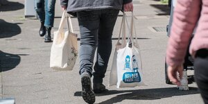Eine Frau trägt ihre Einkaufstaschen in einer Fussgängerzone, Detailaufnahme