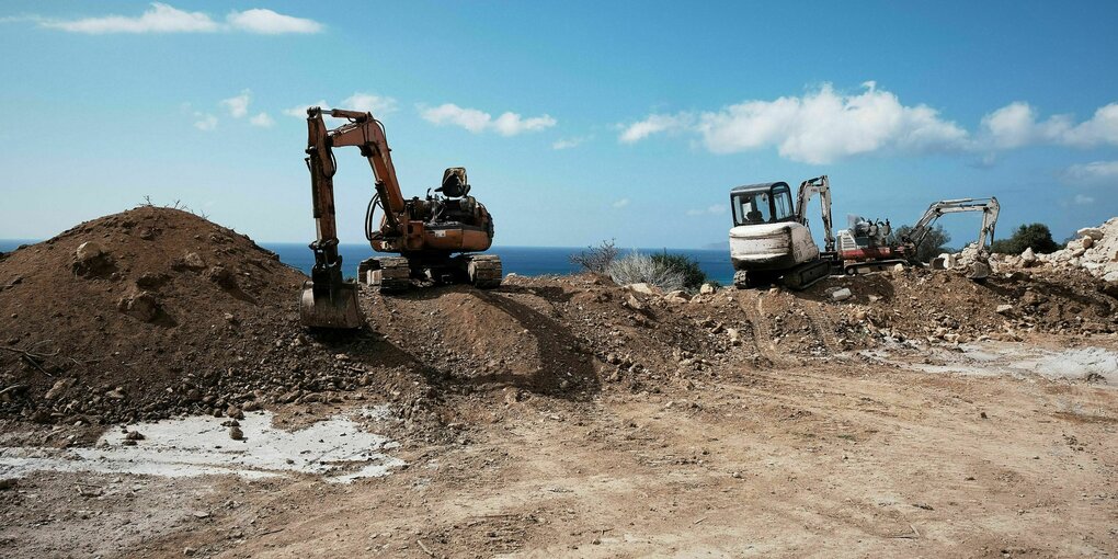 Bagger stehen auf einer Baustelle am Meer