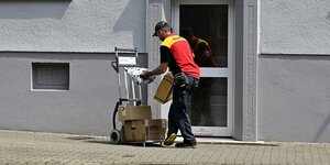 Ein Paketzusteller an einer Haustür
