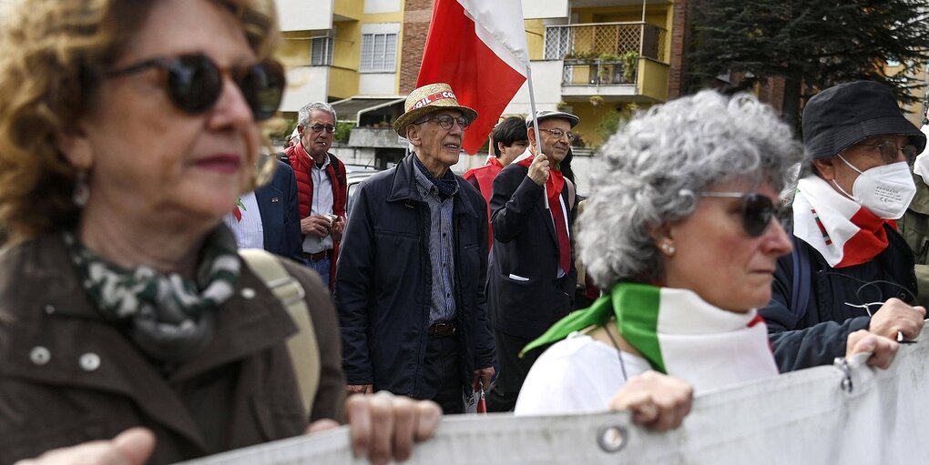 Ein Demonstrationszug, menschen, die nicht mehr jung sind, halten ein transparent