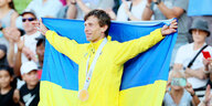 Andrei Protsenko hält ukrainische Fahne hoch