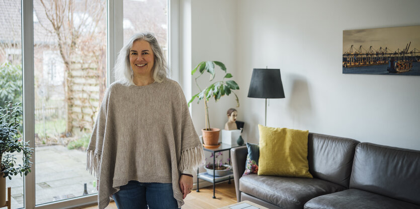 Eine Frau steht vor einem Terrassenfenster