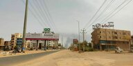 leere Straße in Khartoum, im Hintergrund steigt eine Rauchsäule auf, die auf Kämpfe hinweist
