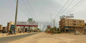 leere Straße in Khartoum, im Hintergrund steigt eine Rauchsäule auf, die auf Kämpfe hinweist