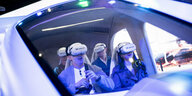 Das Foto zeigt vier Personen mit VR-Brillen in einem Simulator