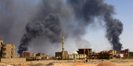 Rauchsäulen stehen über der Stadtsilhouette von Khartum