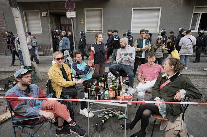 Menschen sitzen auf der Straße und trinken Bier