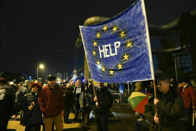 "Help" steht auf einer großen Europaflagge, die von Demonstranten gehalten wird